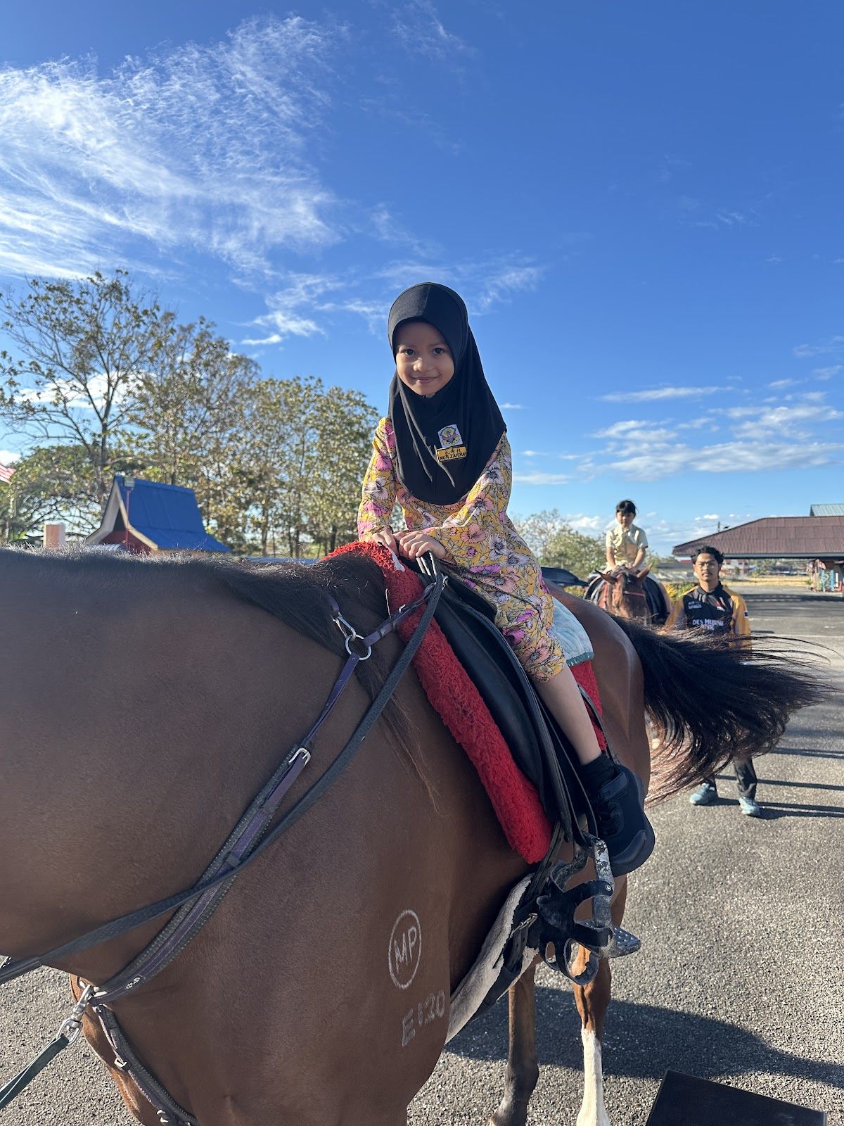 A young pupil riding a horse around the school square at SJKC Khay Beng