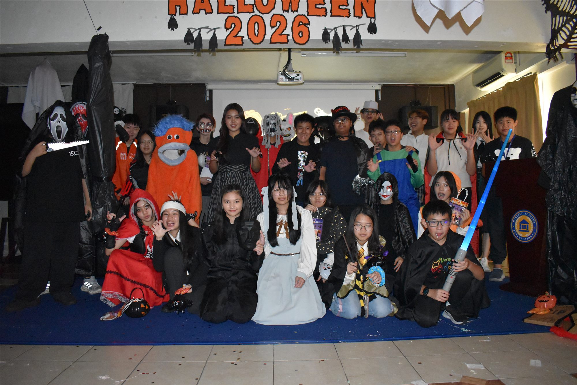 赫威学生和老师穿着万圣节服装,在Halloween 2026横幅下合影