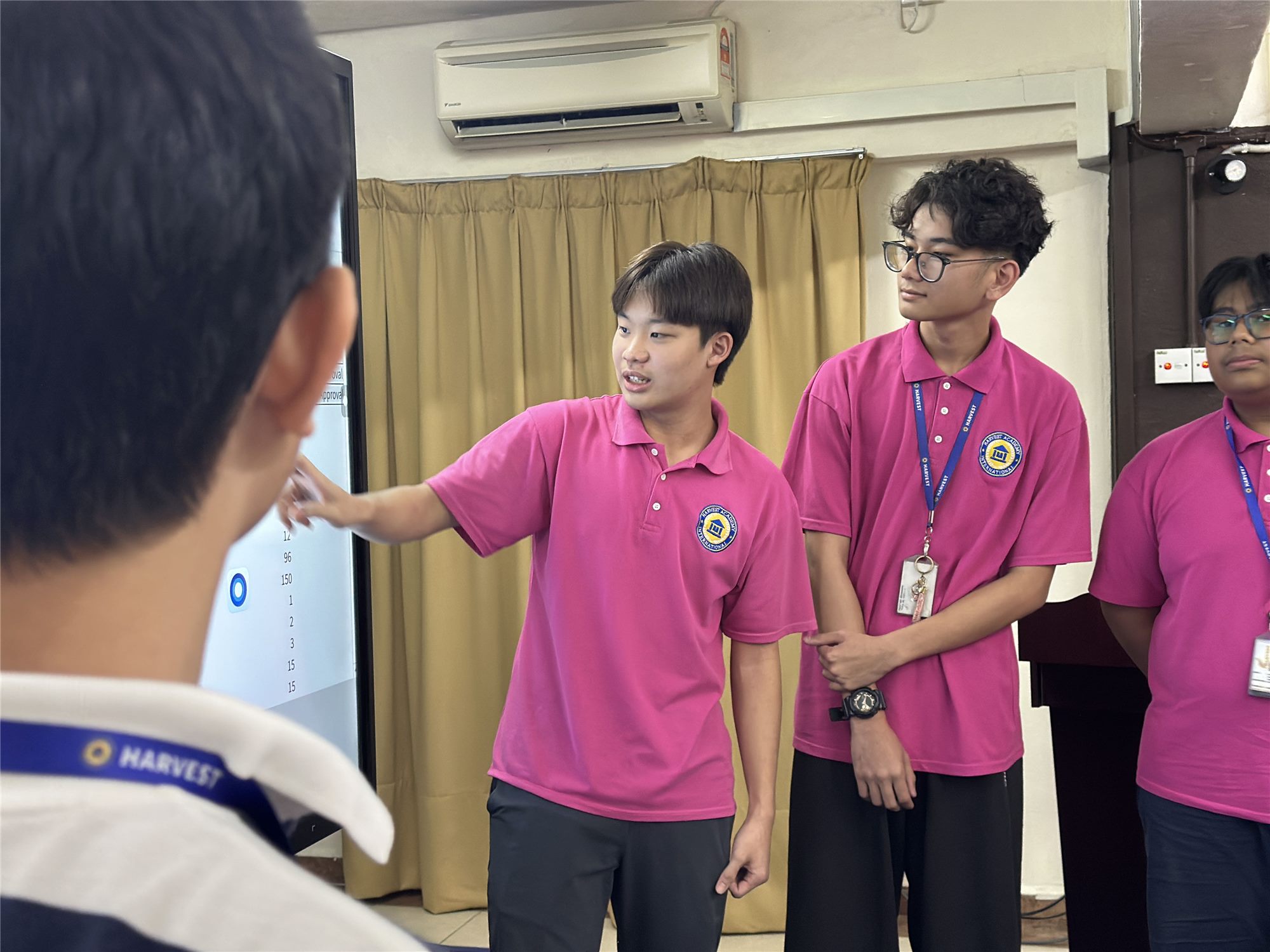 Harvest Academy students presenting confidently to the class on the smartboard